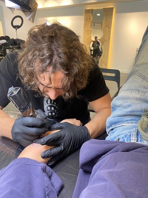 abigail in the chair, brian kies working on her forearm